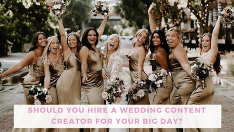 Eight bridesmaids in satiny dresses cheering around their bride in her white wedding dress.