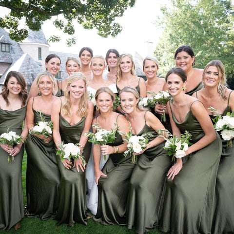 Bride in white slip wedding dress with fourteen bridesmaids in green dresses