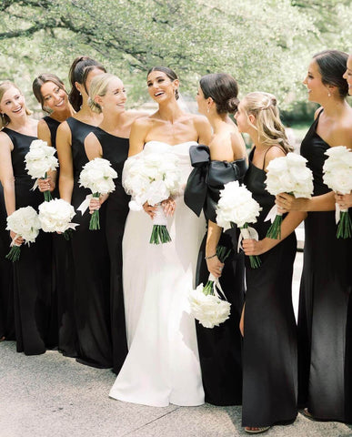 Bride posing with bridesmaids dresses