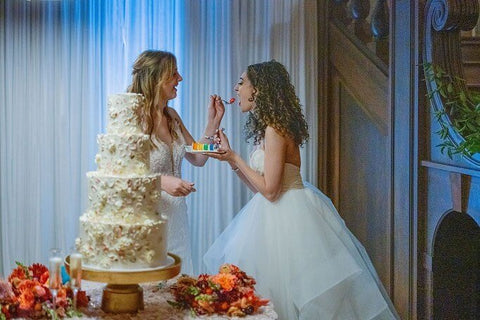 Two brides cutting cake