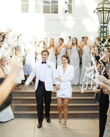 Bride and groom walking down stairs with bridal party behind them