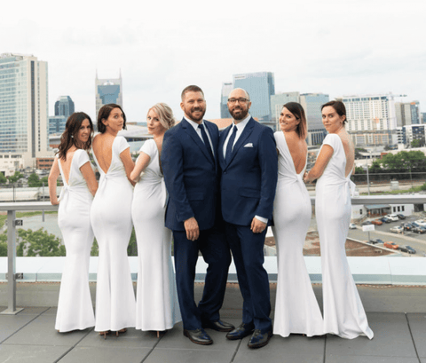 Two grooms in blue suits with five bridesmaids in five suits