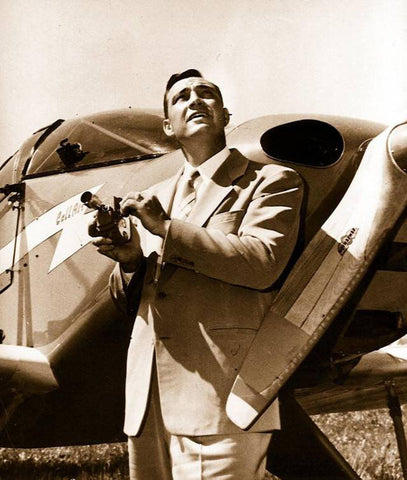 Kenneth Arnold holding his camera in front of his plane