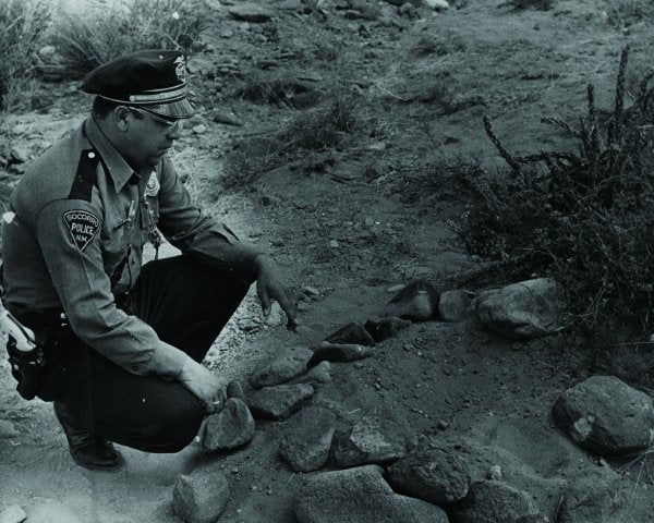 Lonnie Zamora next to an indentation in the desert floor