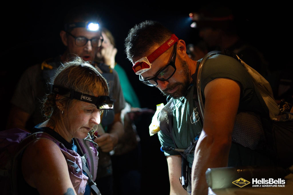 Image of Morgan with team mates in the dark, wearing head torches and wearing an ioMeirno Ultra Tee with Murraylands Multisports Inc print.