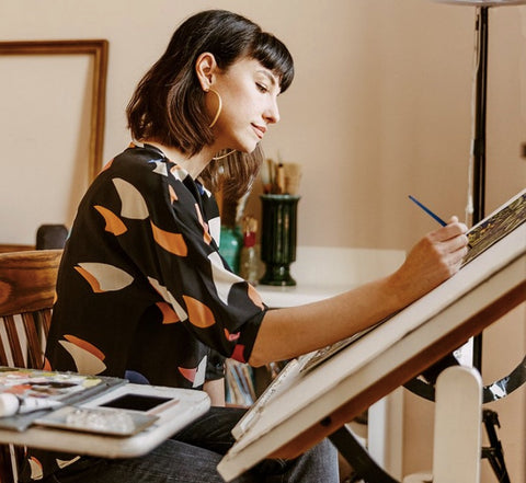 MUSE artist partner Naomi McCavitt drawing at a desk