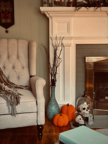 decorative pumpkins and skulls in front of a fireplace