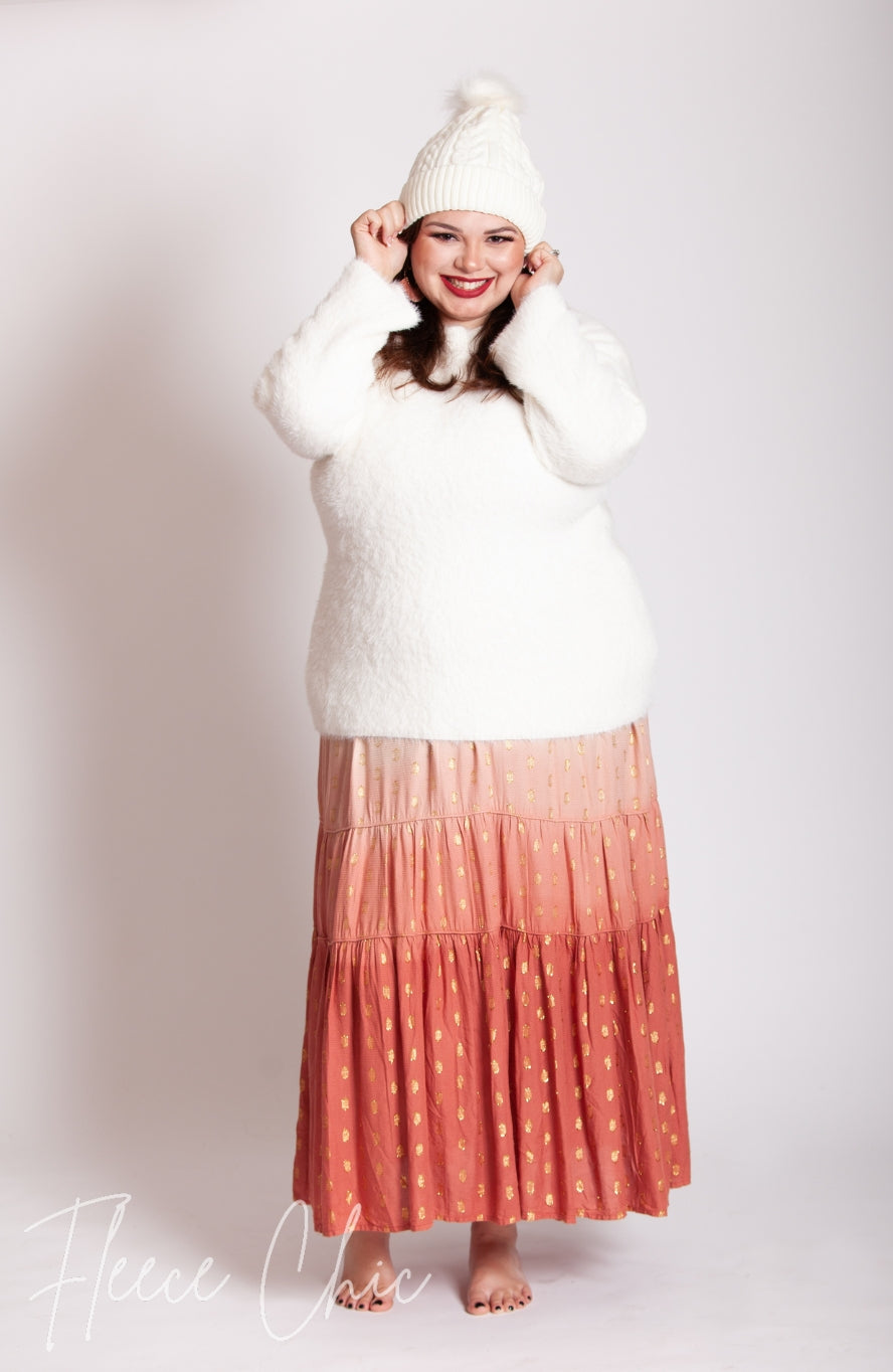 A woman wears a fleece beanie with a faux fur pom pom by Fleece Chic.