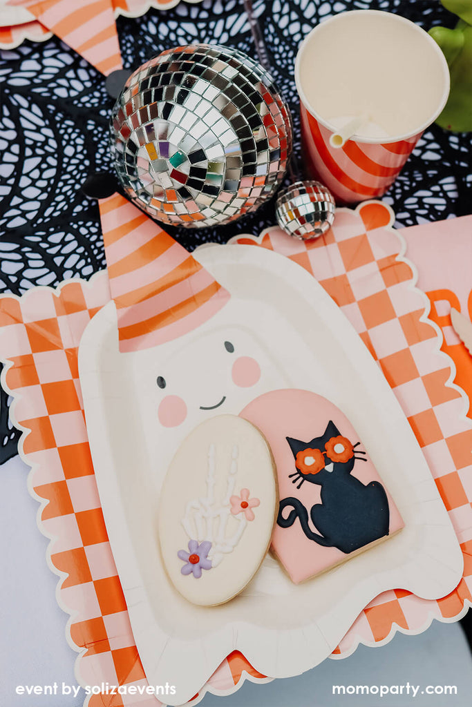Momo Party & Soliza Events Groovy Halloween Tablescape featuring ghost shaped plates and orange and pink checkered plates from momoparty.com