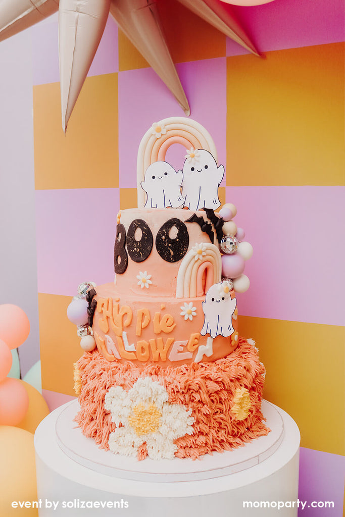 Momo Party and Soliza Events Groovy Halloween Buttercream Cake in orange and pink color with daisy and boho rainbow design, perfect for a kid's friendly Halloween party.