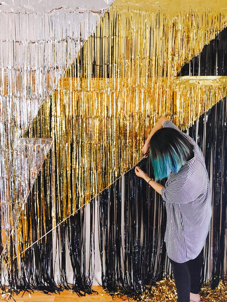 DIY tutorial of lighting bolt photo booth backdrop for Morden Superhero themed birthday party, tutorial step by step image of trimming gold fringe curtain