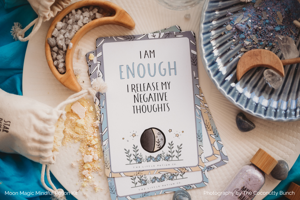 I am Enough affirmation card surrounded by moon magic potion ingredients.