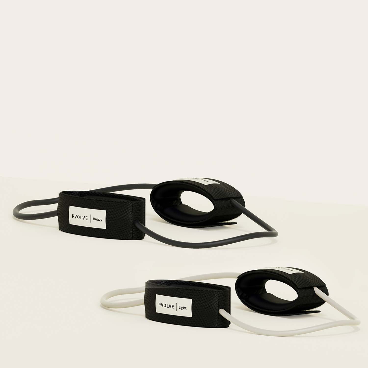 Two black resistance bands labeled 'Pvolve Heavy' and 'Pvolve Light' with padded loops.