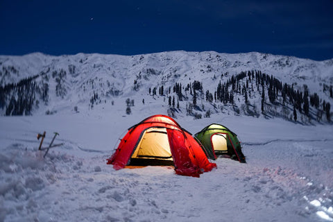 Two tents lit up in the dark in winter. | Heat Holders®