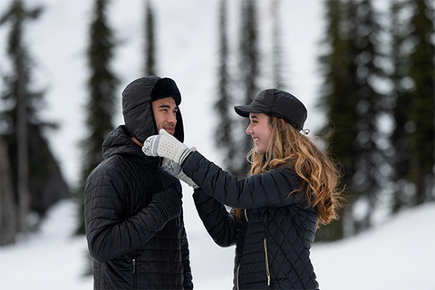 Woman fixes man's winter hat. | Heat Holders®