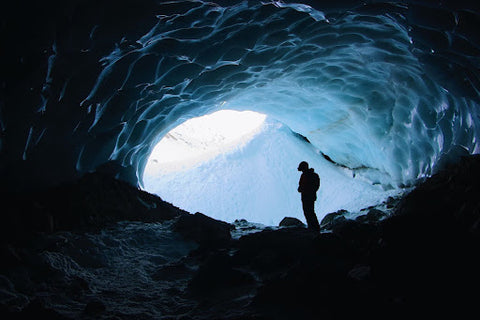 A man stands in an icy cave in winter. | Heat Holders®