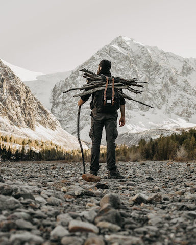 Man carries firewood in the winter. | Heat Holders® Base Layers