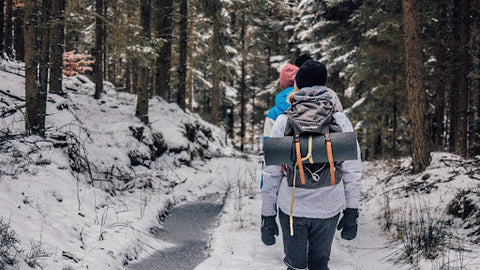 Hikers walk down a trail in winter. | Heat Holders®