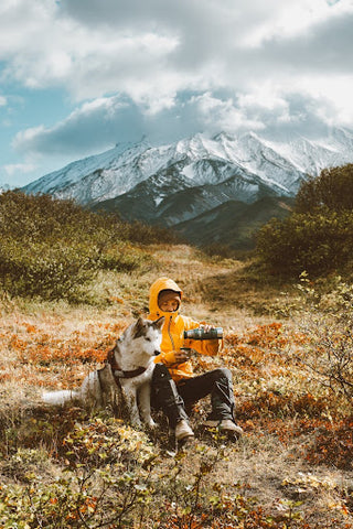 Man sets up camera while his husky looks on. | Heat Holders®