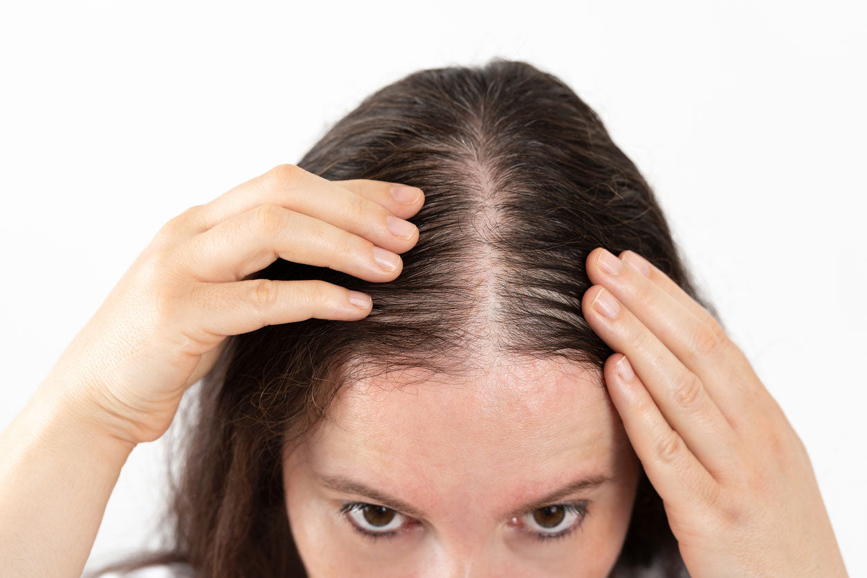 close up of a woman's hair as she checks for hair loss in her scalp