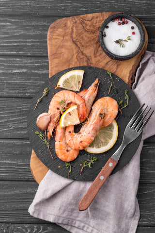 Big shrimps and lemon slices on a plate.