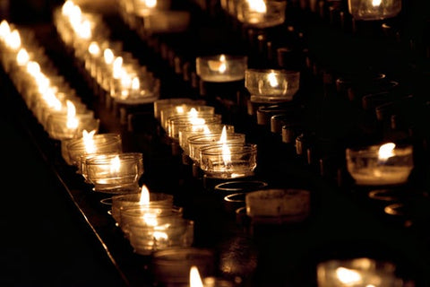 rows-of-lit-tea-candles-in-dark