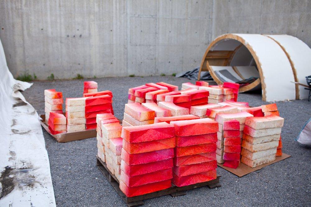 red naturally dyed sculpture pieces stacked on top of one another