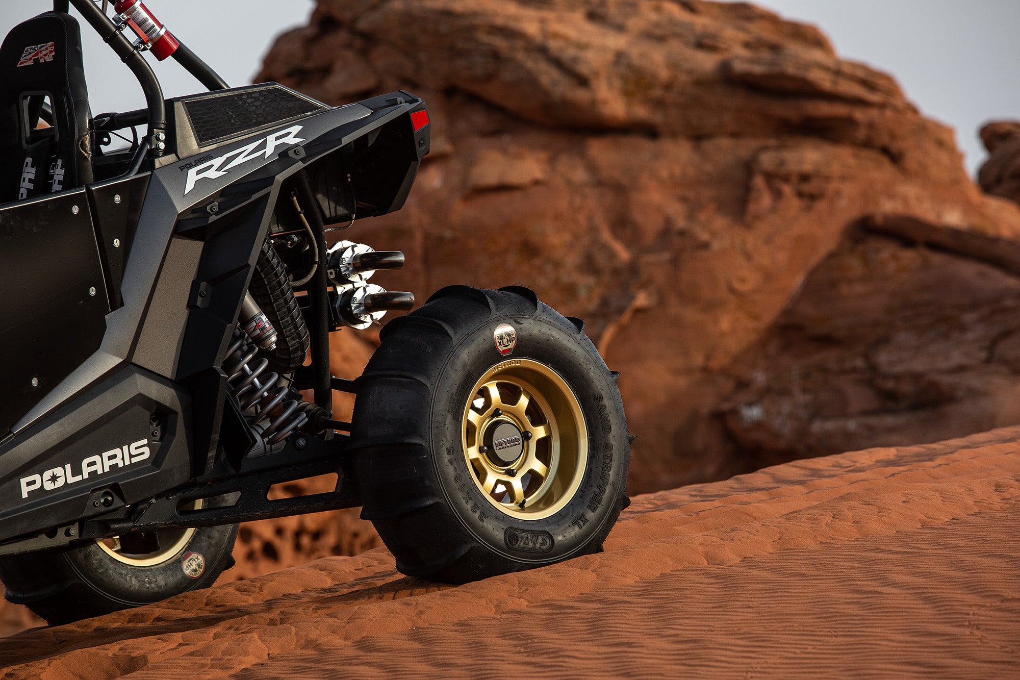 Polaris RZR with Method Race Wheels and Sand Paddle tires in red sand dunes Utah
