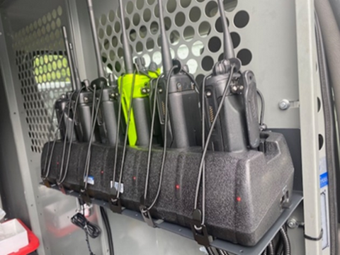 Two-way radios charging on a charger inside a van