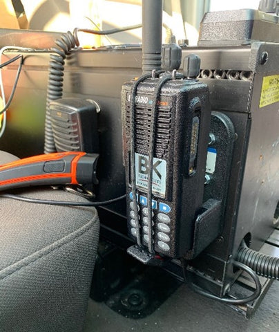 Two-way radio charging inside a car secured by tie down strap