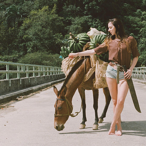 akin _woman wearing akin clothing while petting a donkey