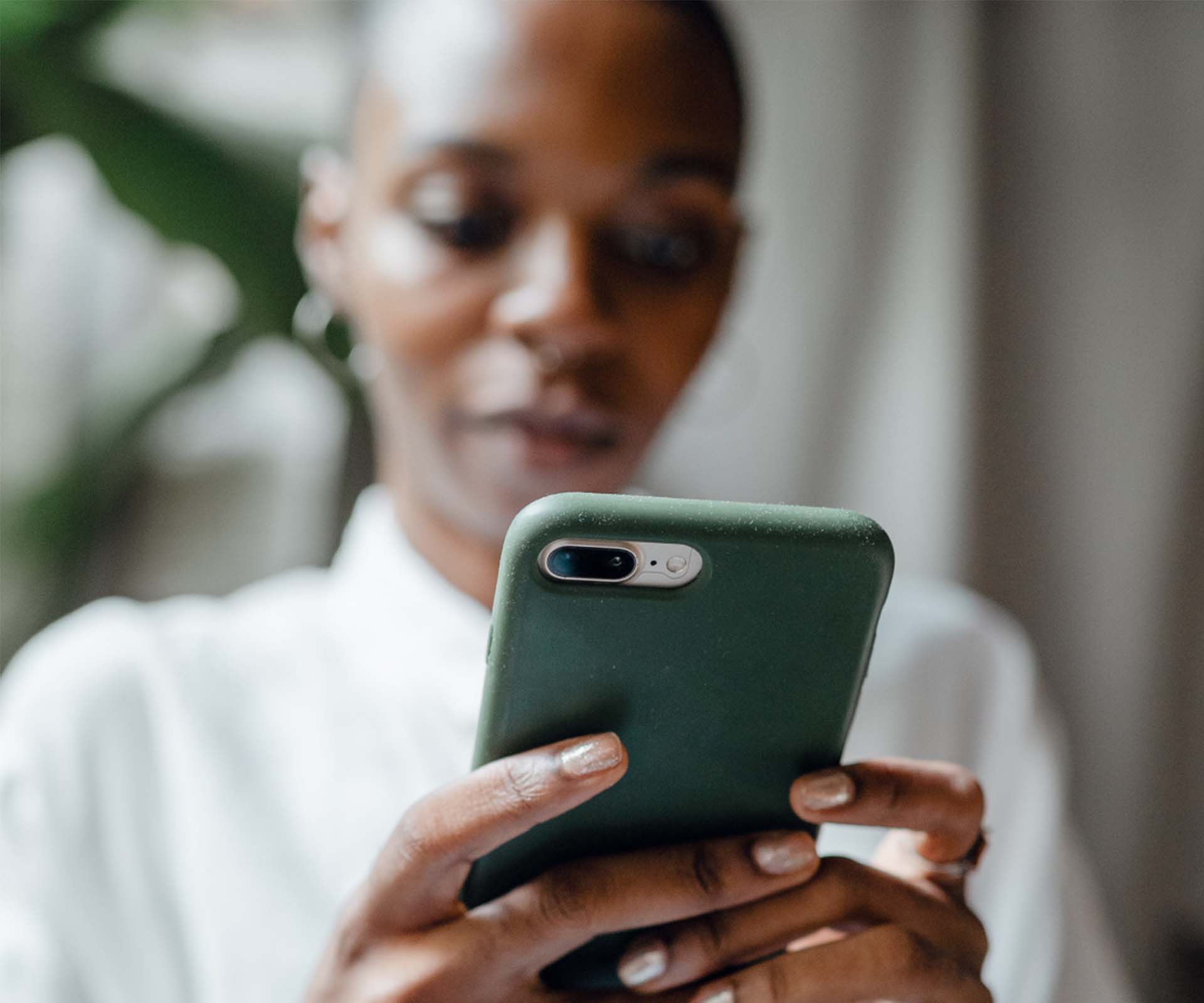 A woman holding and engaging with a smartphone