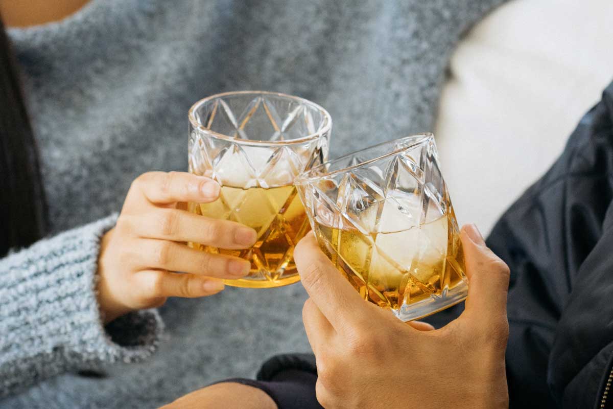 Cheers with two glasses of bourbon