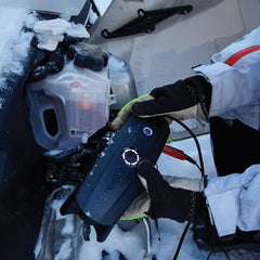CTEK's portable CS FREE charger being used to start a dead snowmobile battery