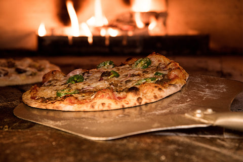 Pizza on a Pizza Peel in a Pizzeria Style Wood Fired Oven