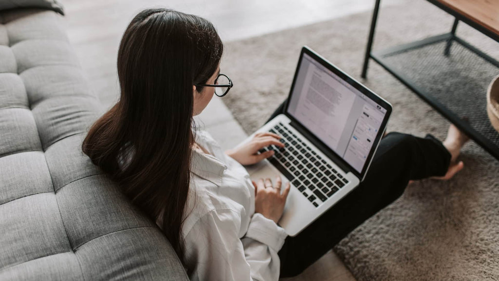 Celebrating the Joy of Work Through the Mighty Pen - A Person Sitting On The Floor Using A Computer | EndlessPens