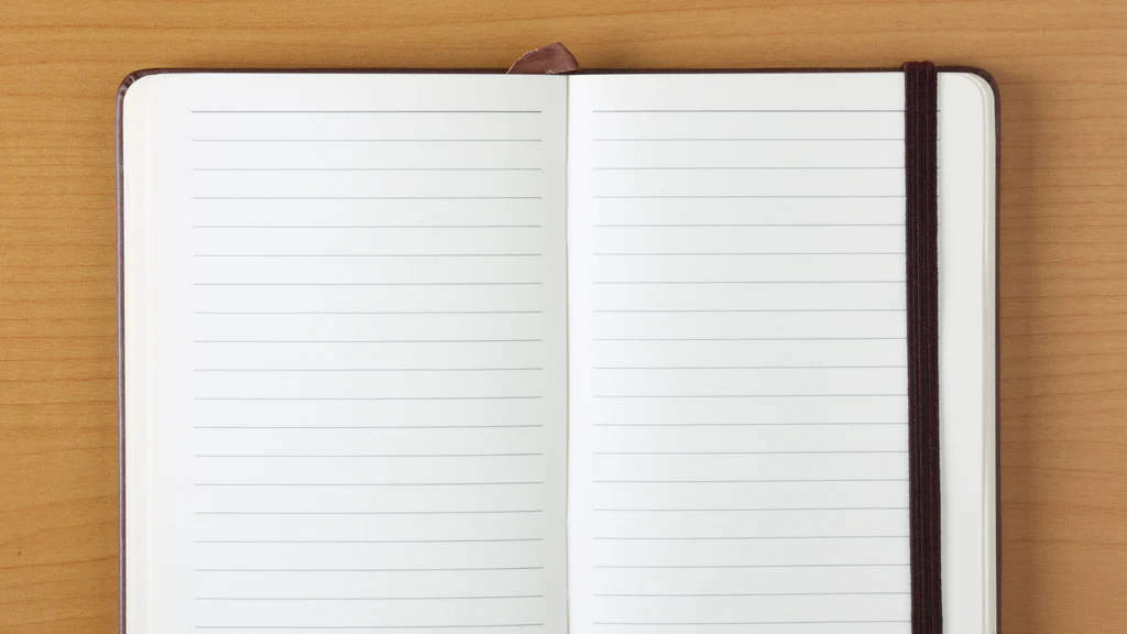 An empty, lined journal, with a black cover