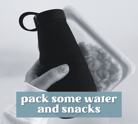 Image of hand holding a collapsible silicone water bottle and nuts in a reusable silicone bag.