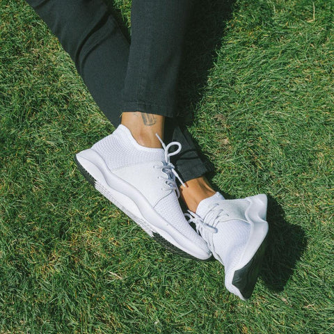 White sneakers on green grass