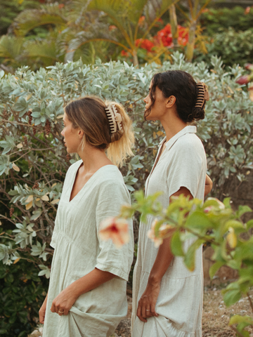 Two women standing in garden with claw clips in their hair