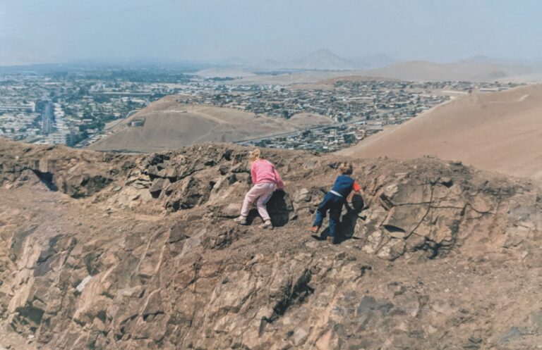 Grossmann and his sister climbing on rocks overlooking their hometown city of Arica, Chile.