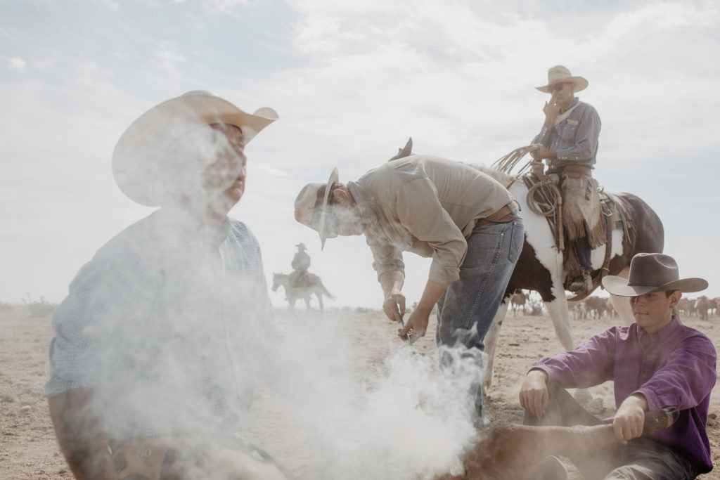 Founder of Ranchlands Duke III, sits on his horse Stephen after roping the calf in on June 15, 2018. His son Duke IV brands it with the diamond star, while Adam and Brandon hold the calf down.