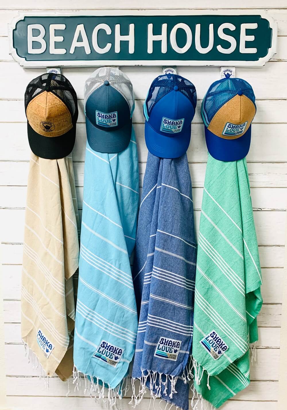 Close-up view of four brightly colored beach towels with matching sustainable hats, perfect for a valentine's day gift