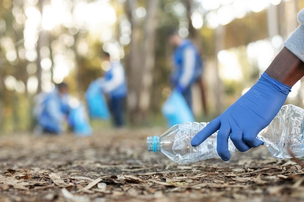 close-up of a hand collecting plastic bottle to create a positive impact and build a better future