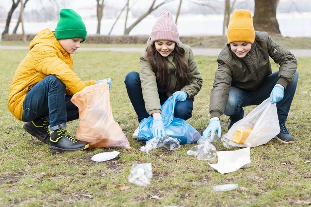 Three kids collect waste and garbage from the forest