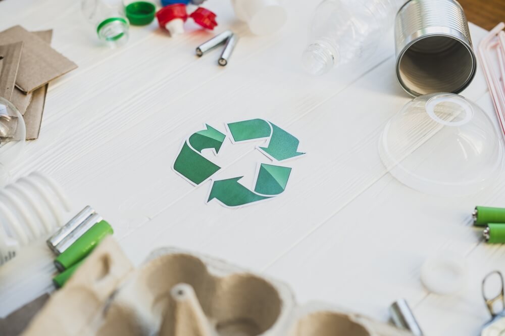 Recycling symbol surrounded by different types of waste