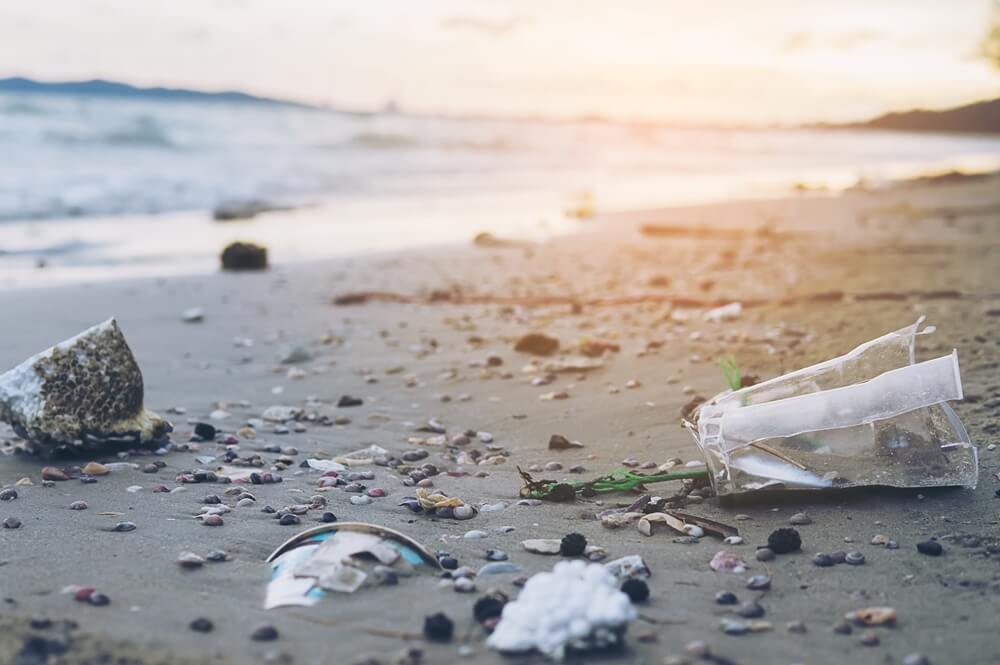 Trash sand beach showing environmental pollution problem, plastic straw pollution