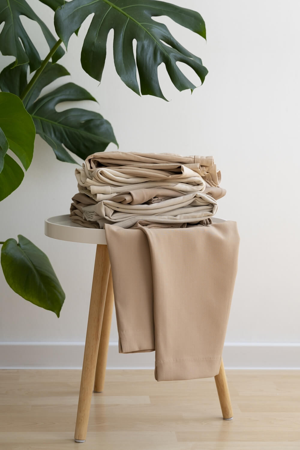 Casual pants made of organic cotton stacked on a stool in a domestic setting