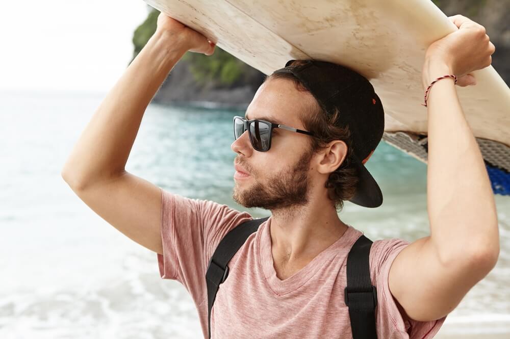 Man enjoying summer while wearing an organic cotton hat for surfing