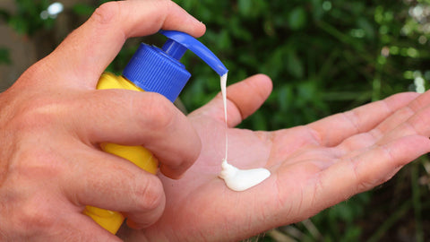 Squeezing suncream into hand